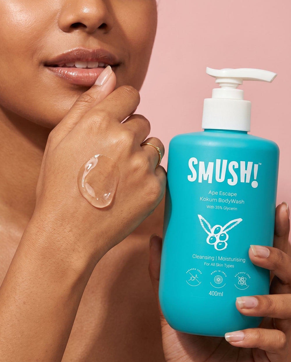 Clear body wash gel on the back of a hand beside the bottle