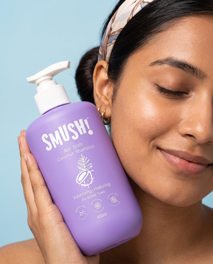 Woman holding Ape Scalp Coconut Shampoo against her cheek
