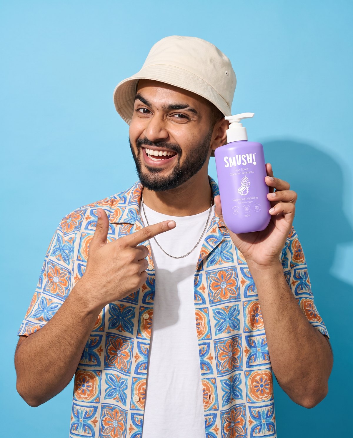 Man in a bucket hat pointing at Ape Scalp Coconut Shampoo on a sky-blue backdrop