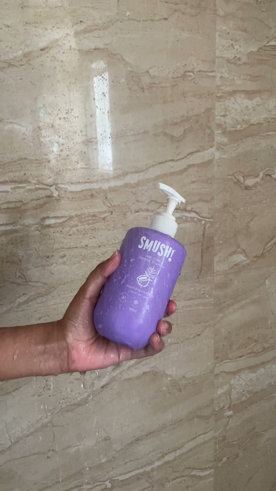 Holding the 400ml Ape Scalp Coconut Shampoo bottle in the shower