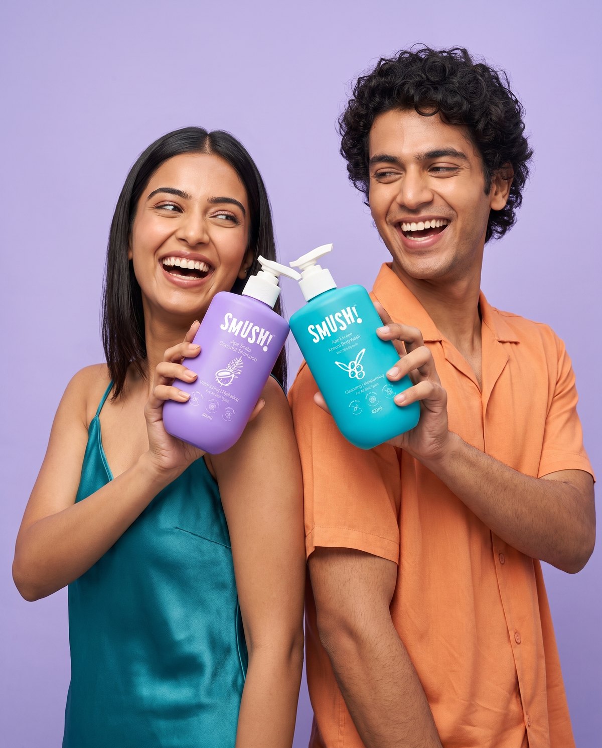 A woman and a man laughing, holding SMUSH! Ape Scalp Coconut Shampoo and Ape Escape Kokum Body Wash